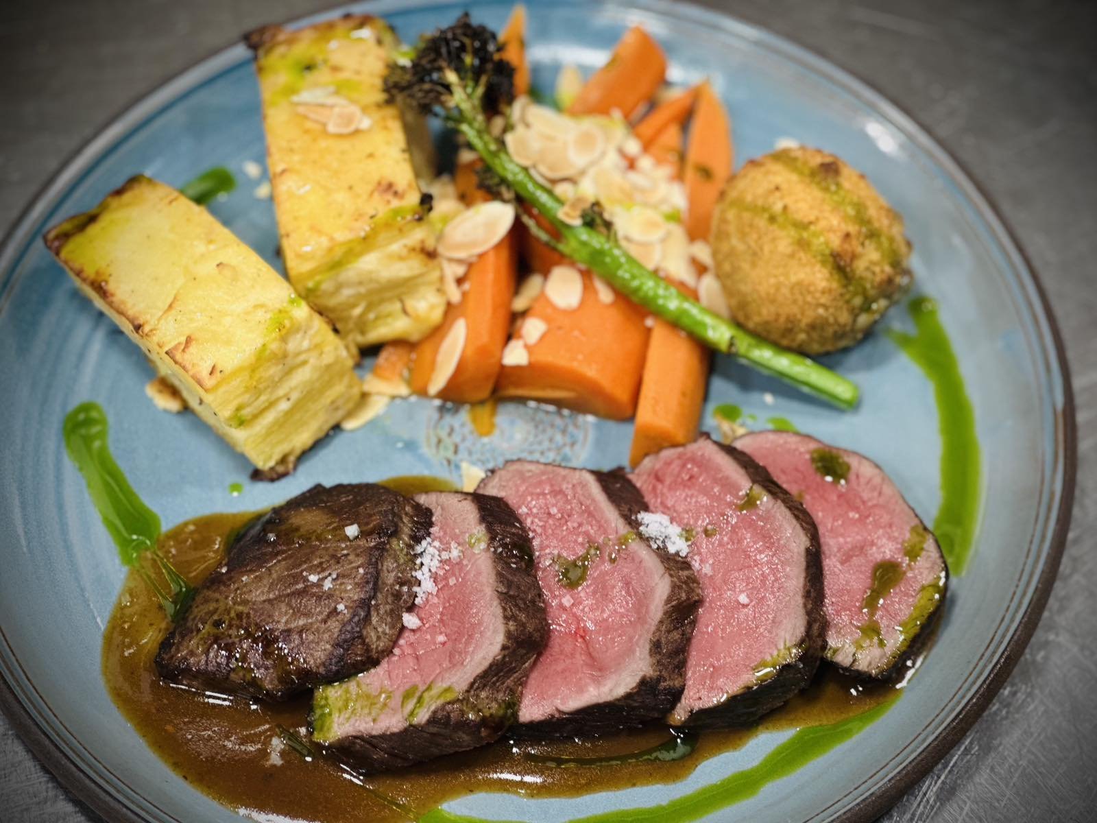 Grillezett szarvas gerinc vörösboros pecsenyelével, gratin burgonyával, gombaropogóssal, mandulás vadbrokkolival és vajas karottával