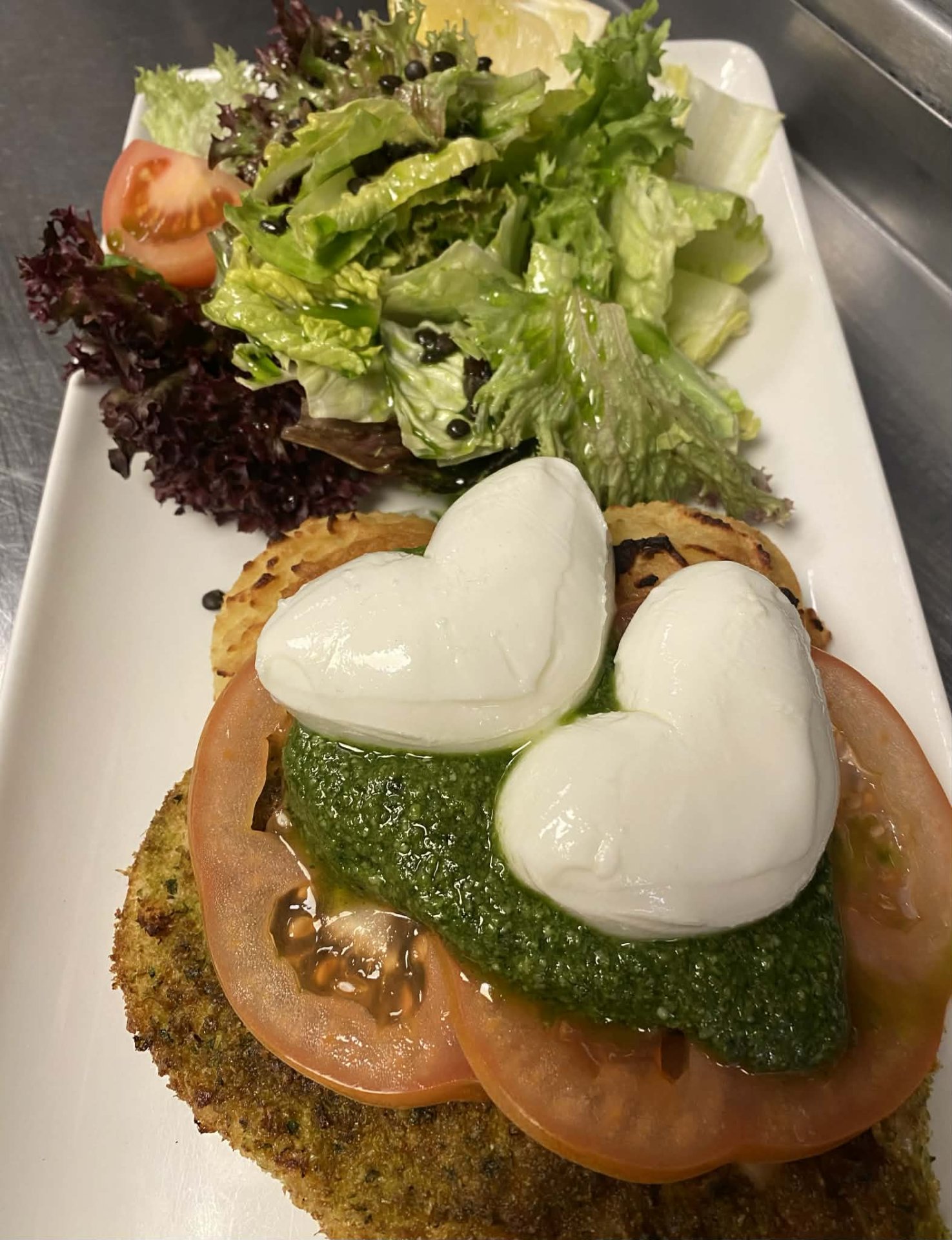 Grillezett zöldmorzsás csirkemell pesto-val, paradicsommal, mozzarellával burgonypürével és salátával